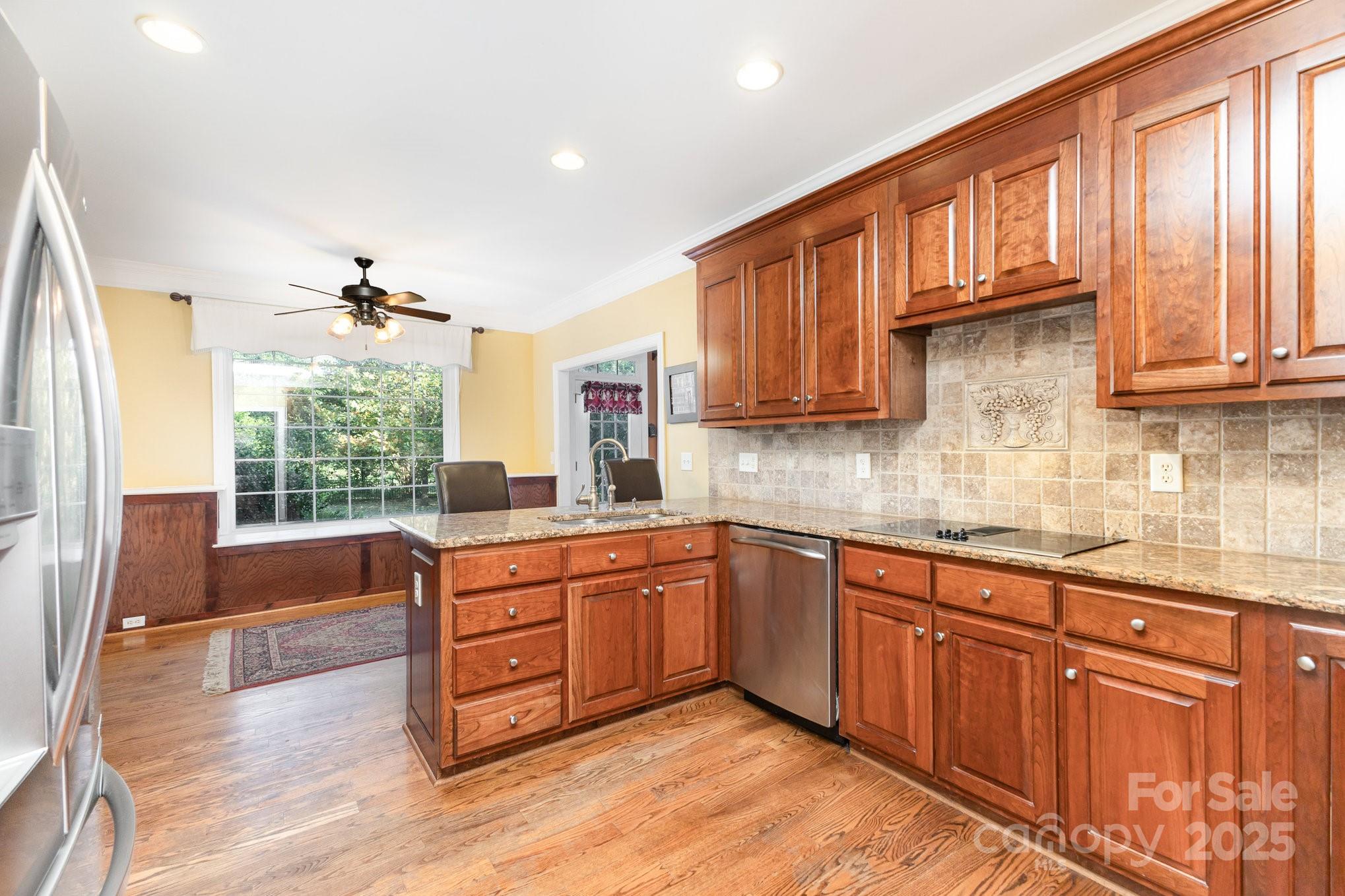 2227 Nash Road Wingate, NC 28174 - Photo 14 of 40 a kitchen with granite countertop wooden cabinets stainless steel appliances a sink and a large window