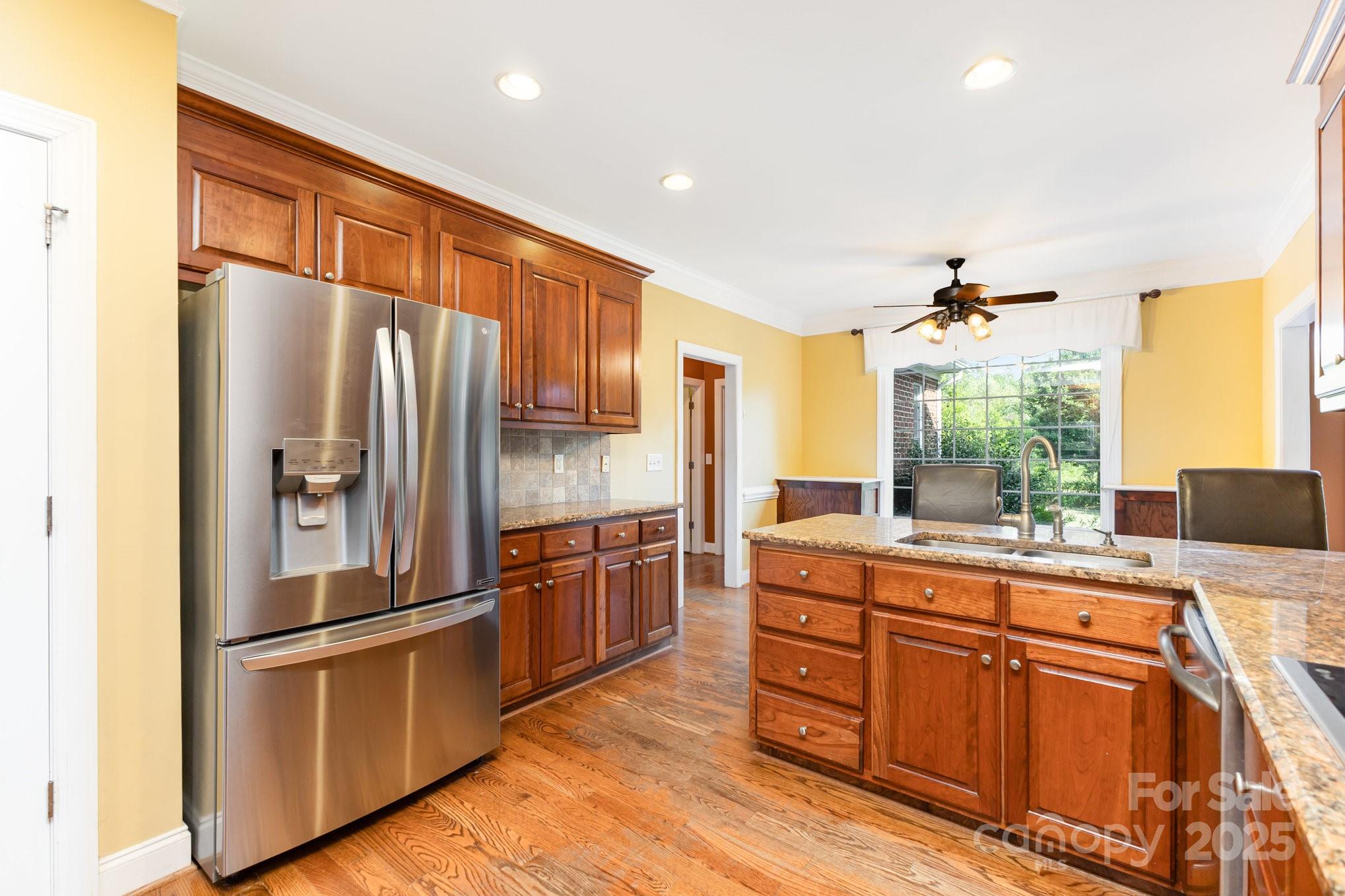 2227 Nash Road Wingate, NC 28174 - Photo 15 of 40 a kitchen with stainless steel appliances granite countertop a refrigerator a stove and a sink with wooden floor