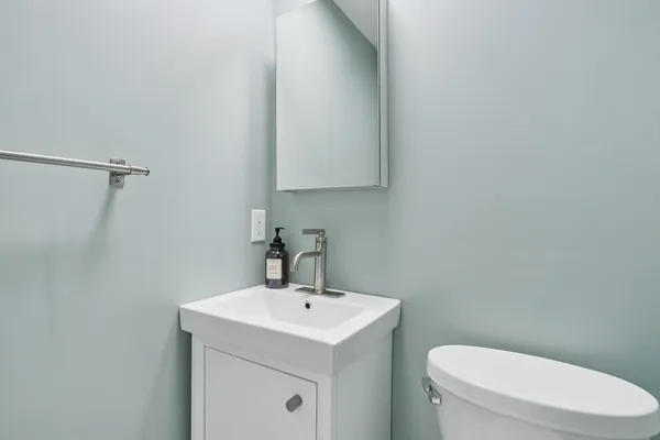 a bathroom with a sink a toilet and mirror