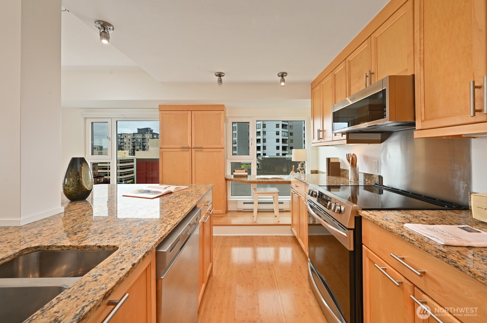 121 Vine Street, Unit 703 Seattle, WA 98121 - Photo 8 of 37 a kitchen with kitchen island granite countertop a stove and a sink