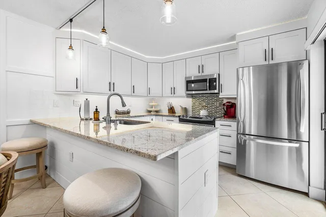 a kitchen with stainless steel appliances a refrigerator sink and microwave