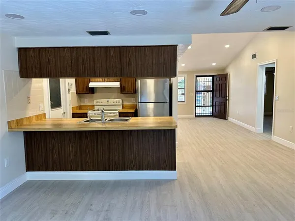 a kitchen with a wooden floor window and cabinets