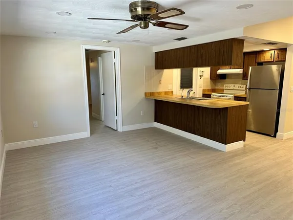 a kitchen with stainless steel appliances kitchen island granite countertop a refrigerator and a sink