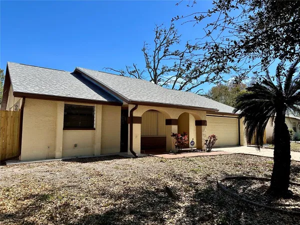 a view of a house with a yard and large tree