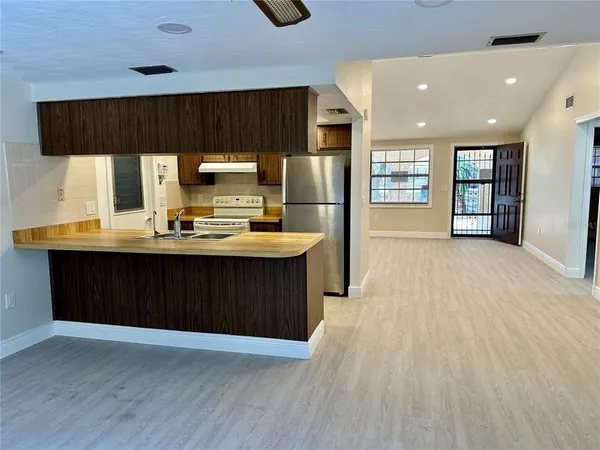 a kitchen with stainless steel appliances wooden cabinets a center island and a refrigerator