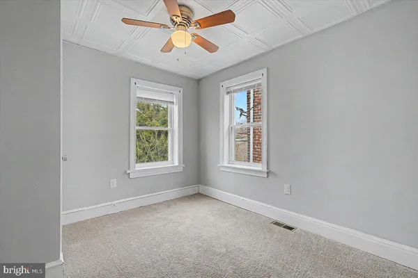 an empty room with a window and a fan