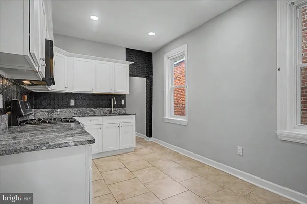 a kitchen with granite countertop a sink stainless steel appliances and cabinets
