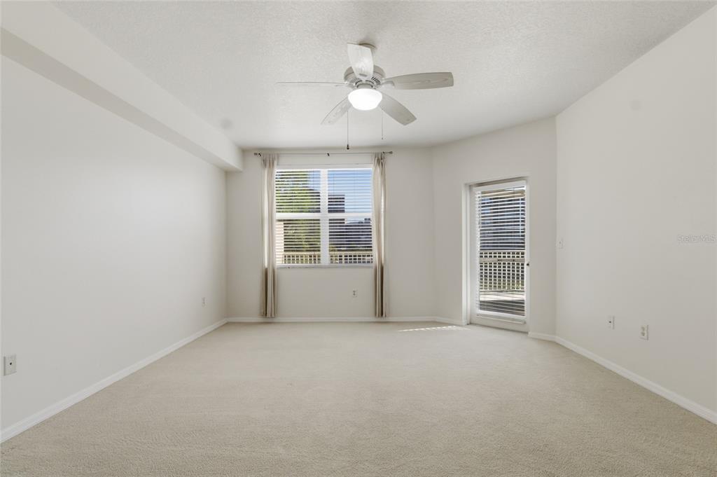 960 Starkey Road, Unit 3106 Largo, FL 33771 - Photo 19 of 39 an empty room with windows and ceiling fan
