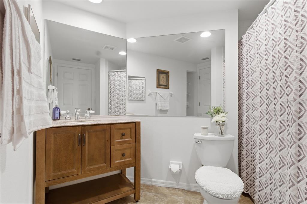 960 Starkey Road, Unit 3106 Largo, FL 33771 - Photo 26 of 39 a bathroom with a sink a toilet a mirror and shower curtain