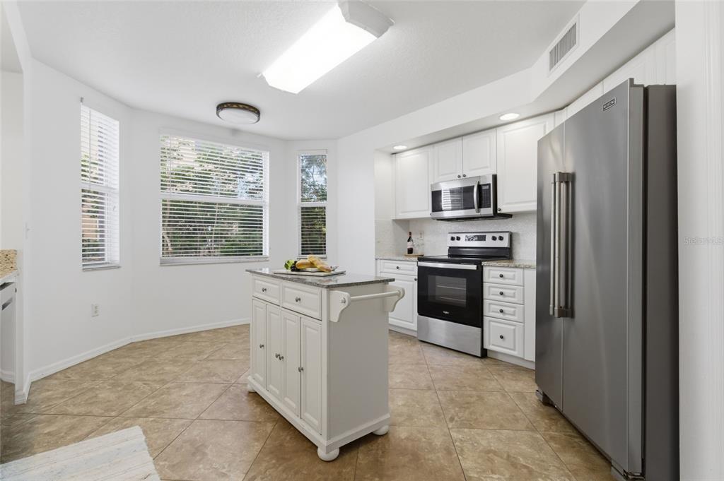 960 Starkey Road, Unit 3106 Largo, FL 33771 - Photo 5 of 39 a kitchen with granite countertop a refrigerator stove top oven and sink