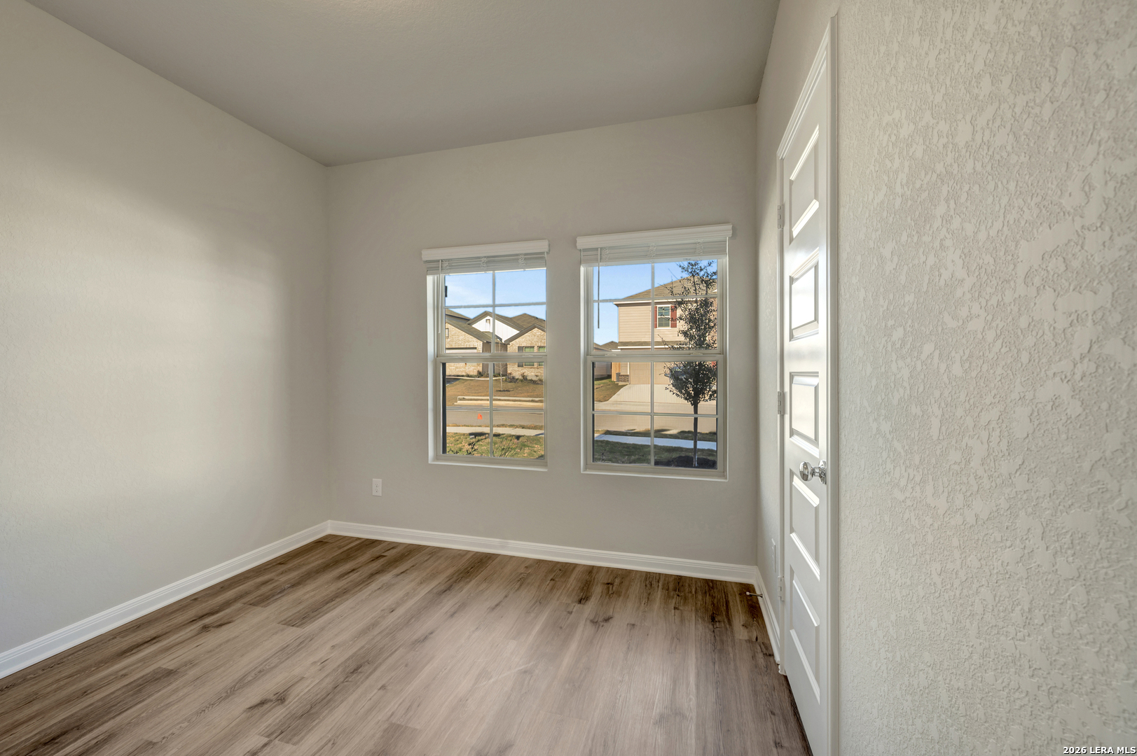 10330 Goodison Drive Converse, TX 78109 - Photo 16 of 42 an empty room with wooden floor and windows