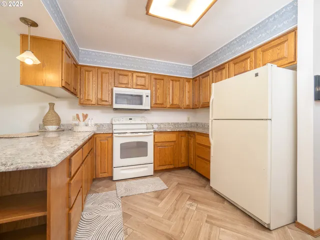 a kitchen with white cabinets and white appliances