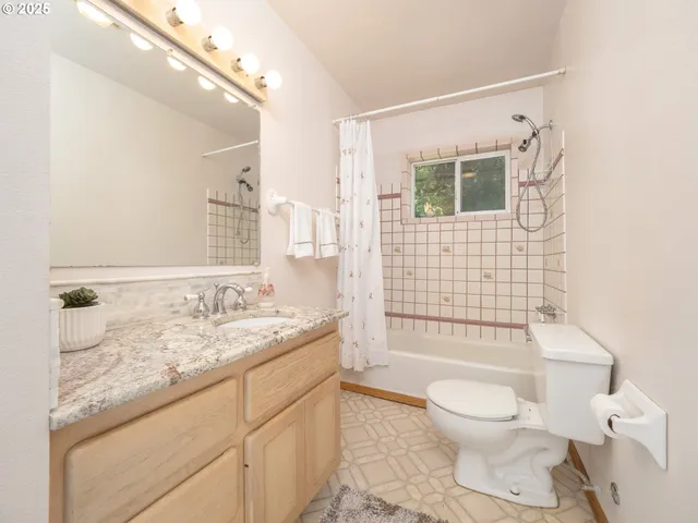 a bathroom with a granite countertop toilet sink and mirror