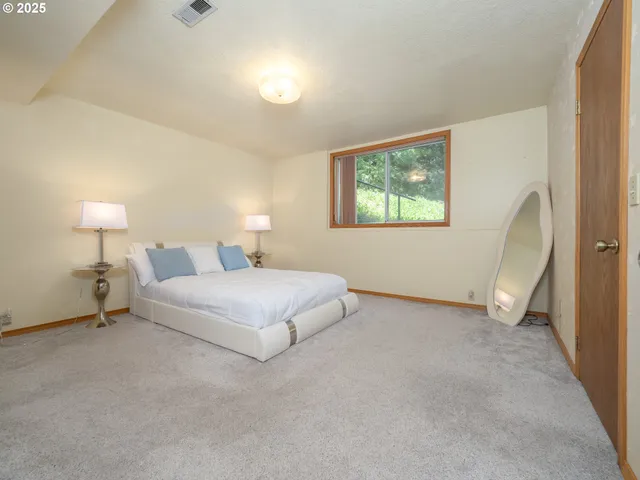 a spacious bedroom with a bed and a window