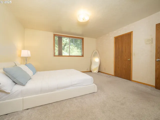 a bedroom with a bed lamp and a window