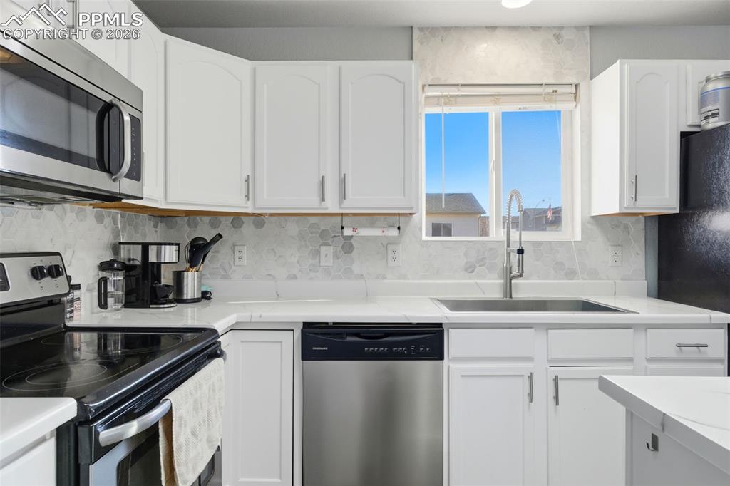 11175 Berry Farm Road Fountain, CO 80817 - Photo 6 of 40 a kitchen with stainless steel appliances granite countertop a sink stove and cabinets