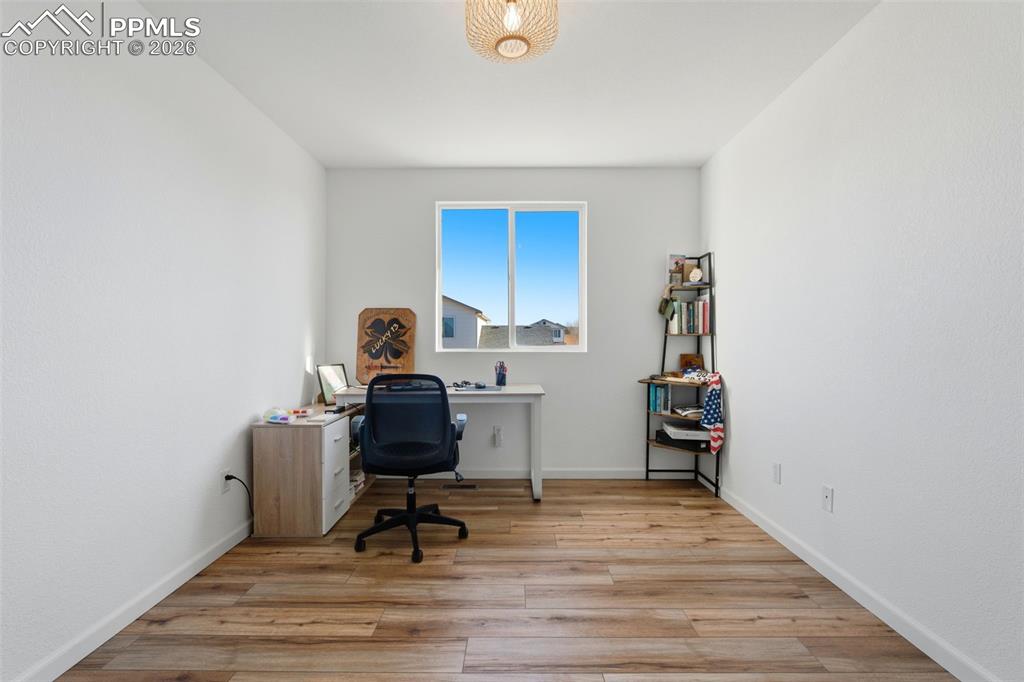 11175 Berry Farm Road Fountain, CO 80817 - Photo 9 of 40 a view of a workspace with furniture and wooden floor