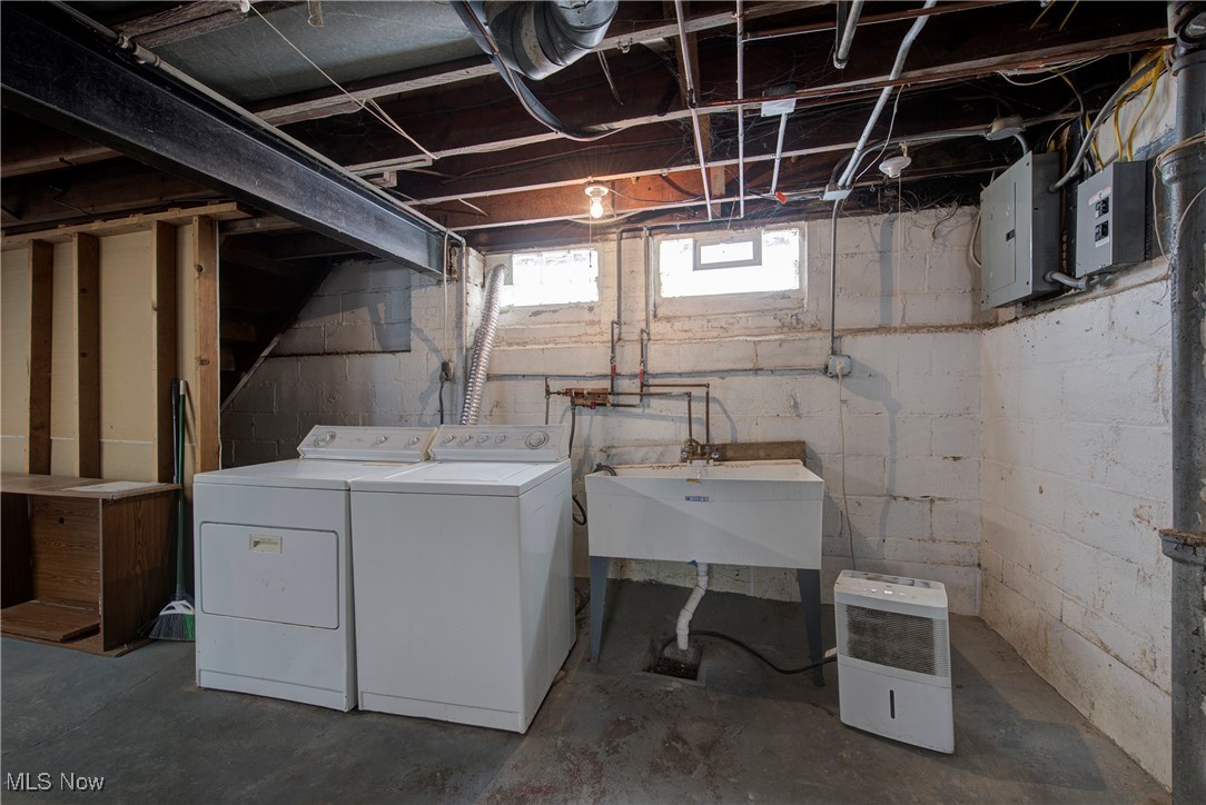 4041 Wilmington Road Cleveland, OH 44121 - Photo 31 of 38 Washroom featuring electric panel, washing machine and clothes dryer, and unfinished concrete flooring
