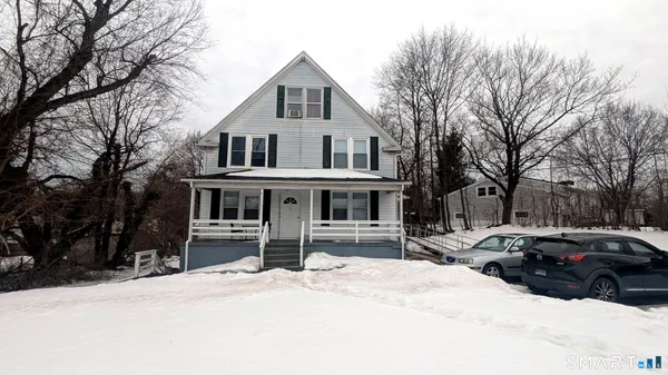 a front view of a house with a yard covered in snow