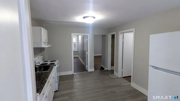 a view of a kitchen with a sink and refrigerator