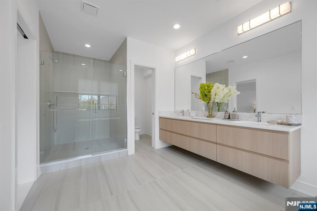 17 Feldman Court Paramus, NJ 07652 - Photo 25 of 47 a bathroom with a double vanity sink and a mirror