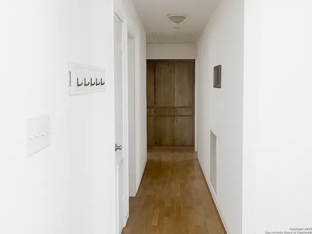 a view of a hallway with wooden floor