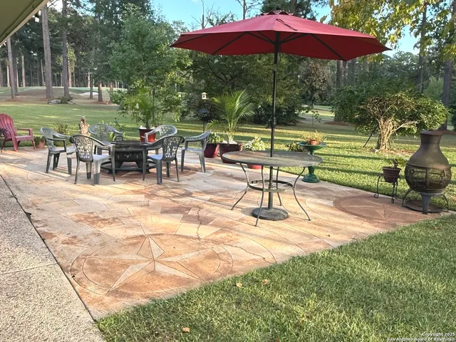 a view of a patio with a table chairs and a yard