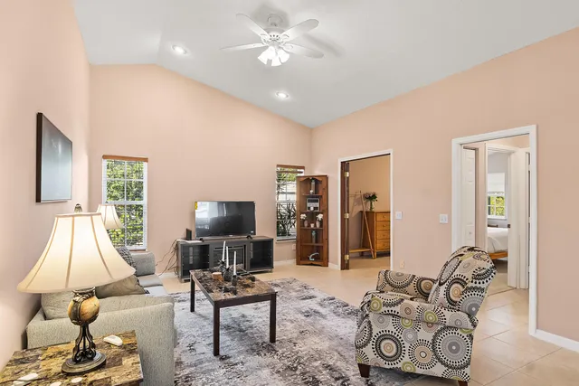 a living room with furniture a flat screen tv and a window