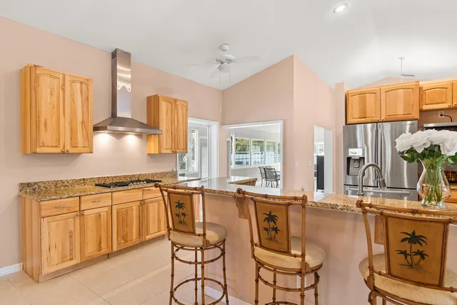 a view of a kitchen with kitchen island granite countertop a large window cabinets and stainless steel appliances
