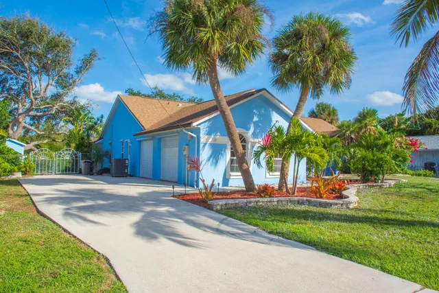 a backyard of a house with table and chairs plants and a barbeque