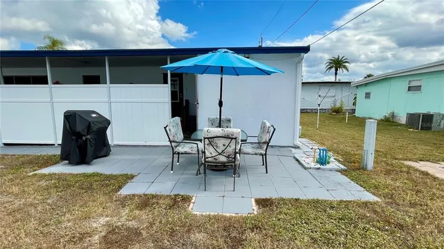 a view of a patio with table and chairs under an umbrella