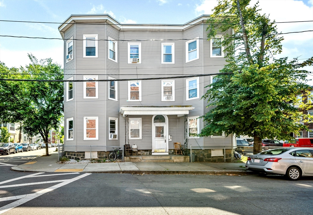 a front view of a house with a garden and parking