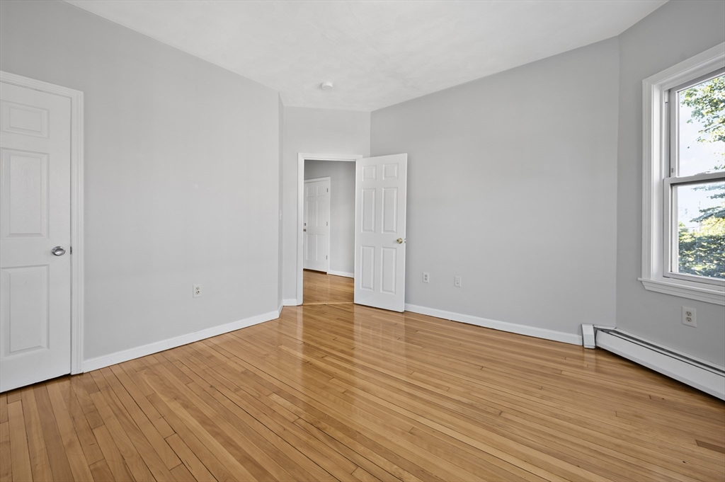 61 Shurtleff Street, Unit 4 Chelsea, MA 02150 - Photo 22 of 32 an empty room with wooden floor and windows