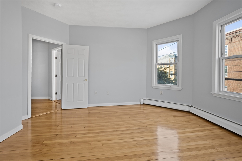 61 Shurtleff Street, Unit 4 Chelsea, MA 02150 - Photo 23 of 32 a view of an empty room with wooden floor and a window