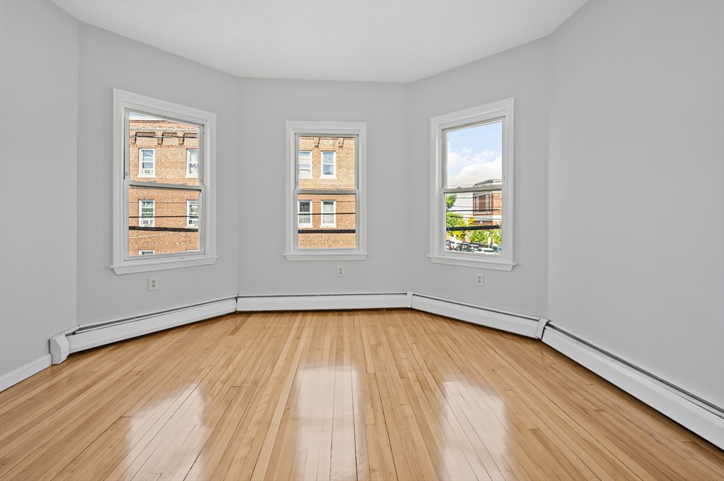 61 Shurtleff Street, Unit 4 Chelsea, MA 02150 - Photo 24 of 32 an empty room with wooden floor and windows