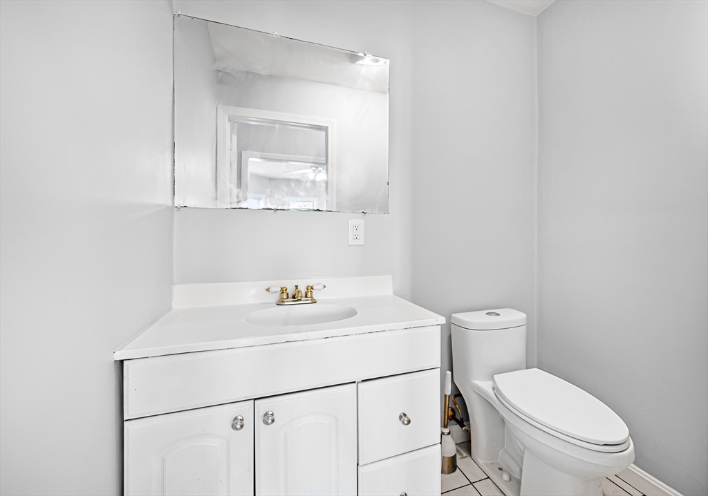 61 Shurtleff Street, Unit 4 Chelsea, MA 02150 - Photo 30 of 32 a bathroom with a toilet sink vanity and mirror