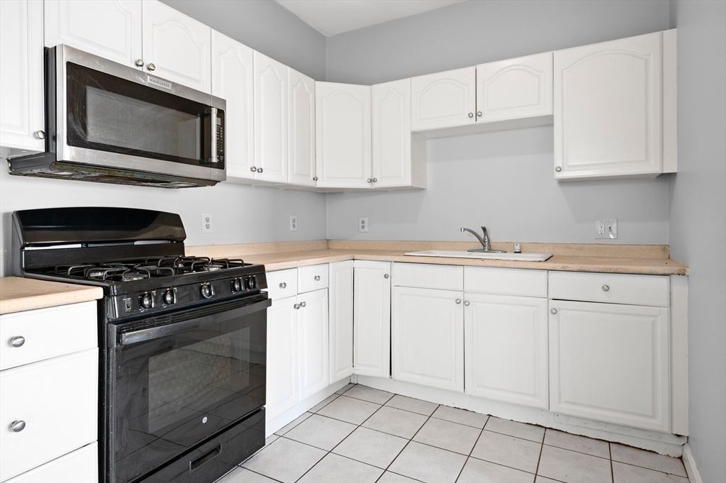 61 Shurtleff Street, Unit 4 Chelsea, MA 02150 - Photo 3 of 32 a kitchen with white cabinets and appliances