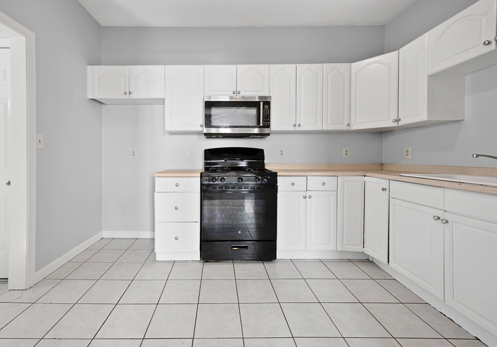 61 Shurtleff Street, Unit 4 Chelsea, MA 02150 - Photo 4 of 32 a kitchen with white cabinets and appliances