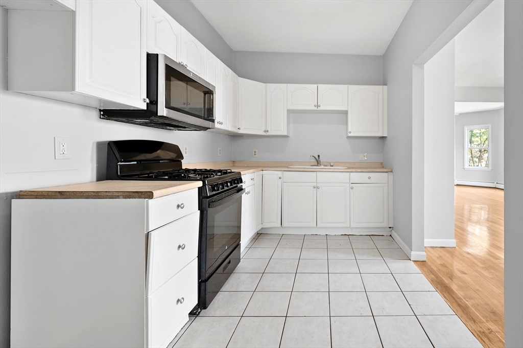61 Shurtleff Street, Unit 4 Chelsea, MA 02150 - Photo 5 of 32 a kitchen with a stove a sink and a microwave