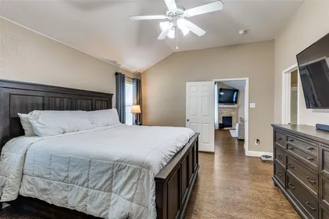 a bedroom with a large bed and a flat tv screen