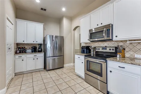 a kitchen with stainless steel appliances granite countertop a refrigerator sink and stove