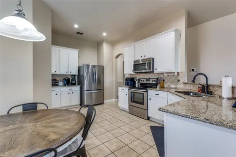 a kitchen with kitchen island a counter space a sink appliances and cabinets