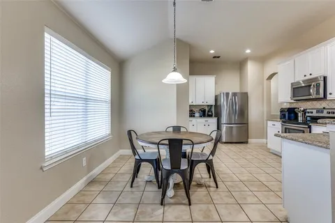 a dining area with furniture a window and stainless steel appliances