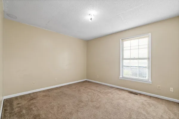 an empty room with a window and closet