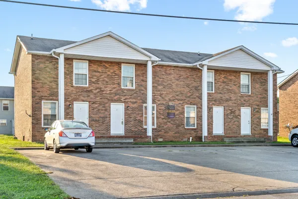 a car parked in front of a white house