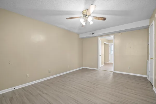 a view of an empty room with wooden floor