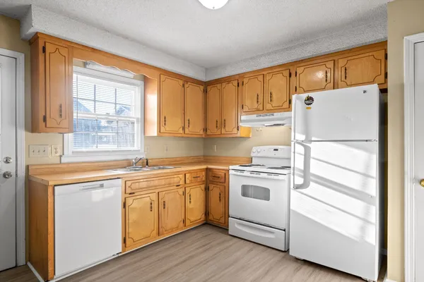 a kitchen with white cabinets and white appliances