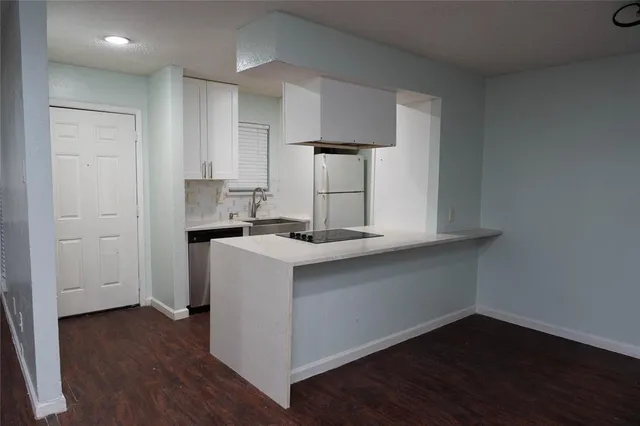 a kitchen with a sink cabinets and wooden floor