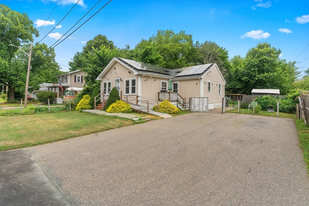 a view of a house with a big yard and large trees