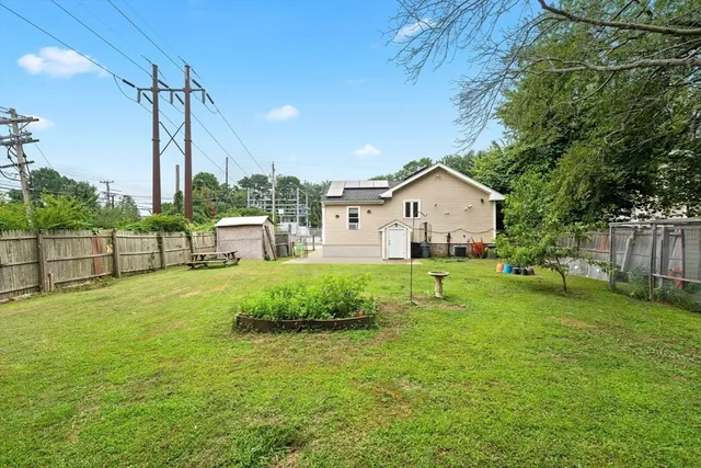 a view of a house with backyard and a tree